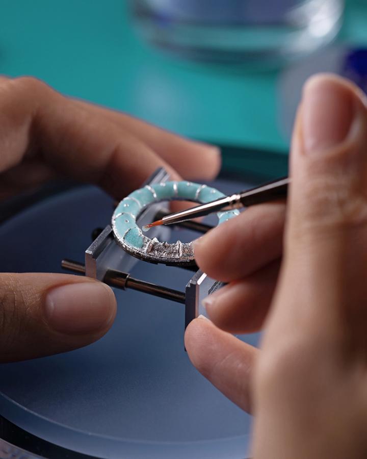 珐琅工艺师于 Tiffany 珐琅钻石腕表上涂覆一层半透明彩色珐琅。