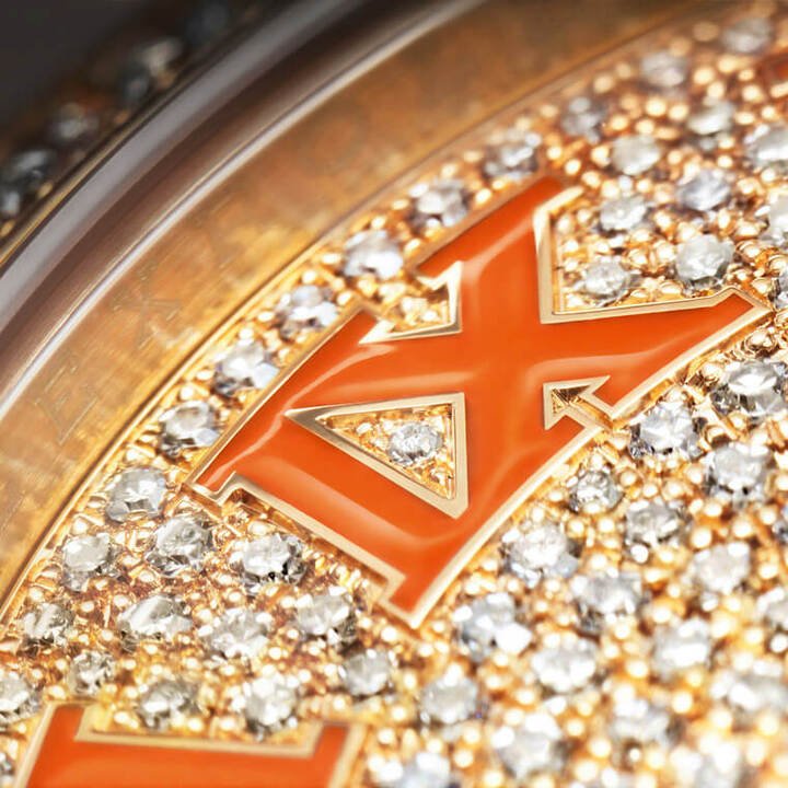 面盘的金质罗马数字时标填上彩色珐琅，随着表壳颜色不同，时标上的珐琅颜色也会有所不同，例如黄金表壳就是配珊瑚色珐琅