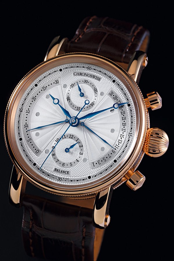 瑞宝表（Chronoswiss）The Balance双回拨腕表，集高超制表技术及优雅设计于一身，精美的机刻花纹表盘显示布局平衡有致，将自动上链计时机芯的功能烘托得更悦目可人，从容展现简洁布局的美感。