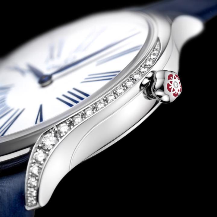 Trésor之表壳两侧的曲线皆镶嵌了耀眼钻石，表冠中间亦镶嵌著一颗美钻。以红色的液态陶瓷结合五个欧米茄商标构成花朵图案，做为表冠的额外装饰