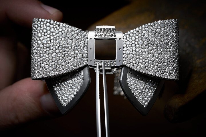 Nœud de Diamants 手环表，以全手工雪花式镶嵌工艺，将 3306 颗总重约 45.43 克拉明亮式切割钻石精心排列于 18K 铸造白金表面，工艺极其复杂。每颗钻石大小都经过精心挑选，并以手工定位，最终呈现层次丰富、质感效果十足。
