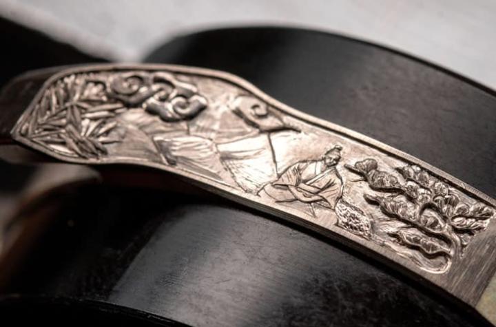 中层表壳以手工雕刻细腻描绘武士战斗与冥想对比，展现力量与静谧并存的叙事张力。