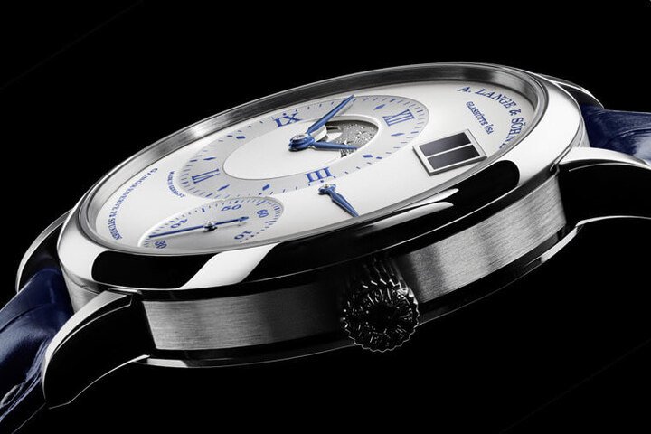 Grand Lange 1 Moon Phase “25th Anniversary”纪念表同样以白金材质制作表壳，同时面盘细节一律换上蓝色，搭配蓝色鳄鱼皮表带呈现共同主题性
