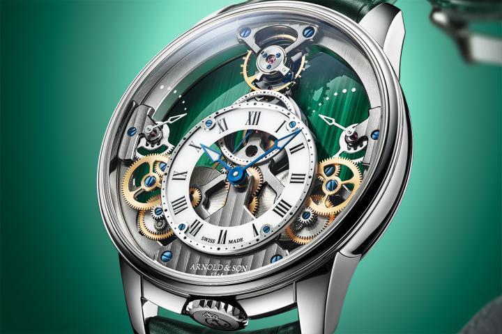 A&S1615 手动上链机芯大幅镂空的主板上承载着多项关键部件，包括 12 点钟位置的摆轮，以及成对配置的动力储存显示。齿轮传动自 6 点钟位置的双发条盒起始，沿着清晰的轴线延伸至 12 点钟位置的调速系统。