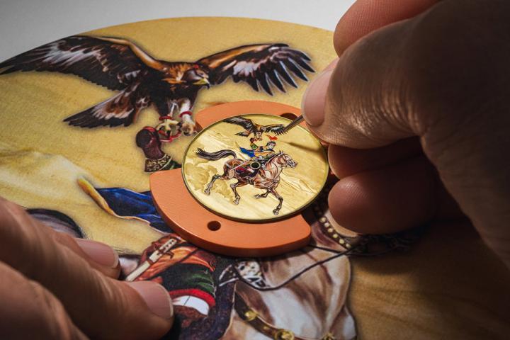 每一枚腕表的 18K 黄金表盘上，均以大明火微绘珐琅彩绘工艺栩栩描绘出英雄身姿，背景则采用手工雕刻工艺，以雾面与亮面的层次交错，生动再现英雄建功疆场的壮阔场景。