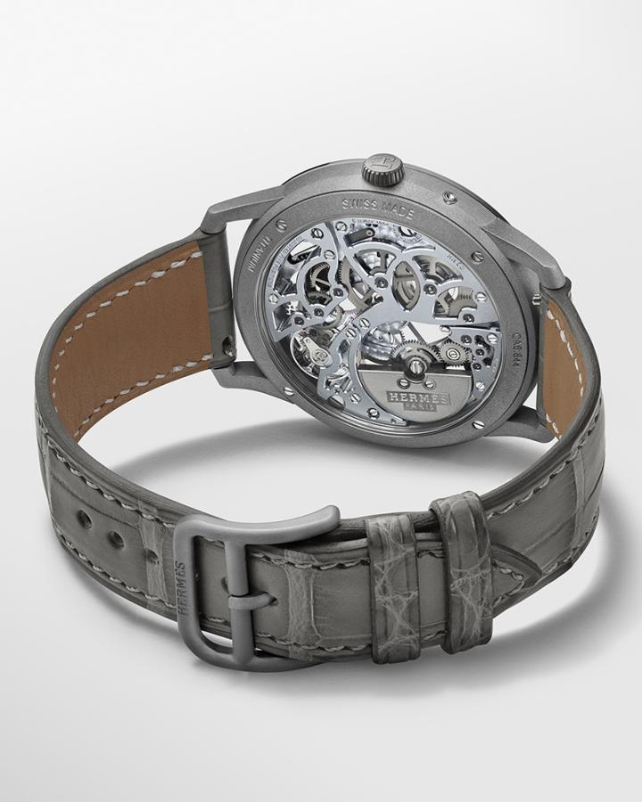 这款腕表的心脏为爱马仕自制 H1953 镂空超薄自动上链机芯，它驱动小时与分钟指针，以及南北半球月相显示。镂空的夹板桥透过蓝宝石水晶底盖可一窥其结构之美，而且其色调与表盘一致。