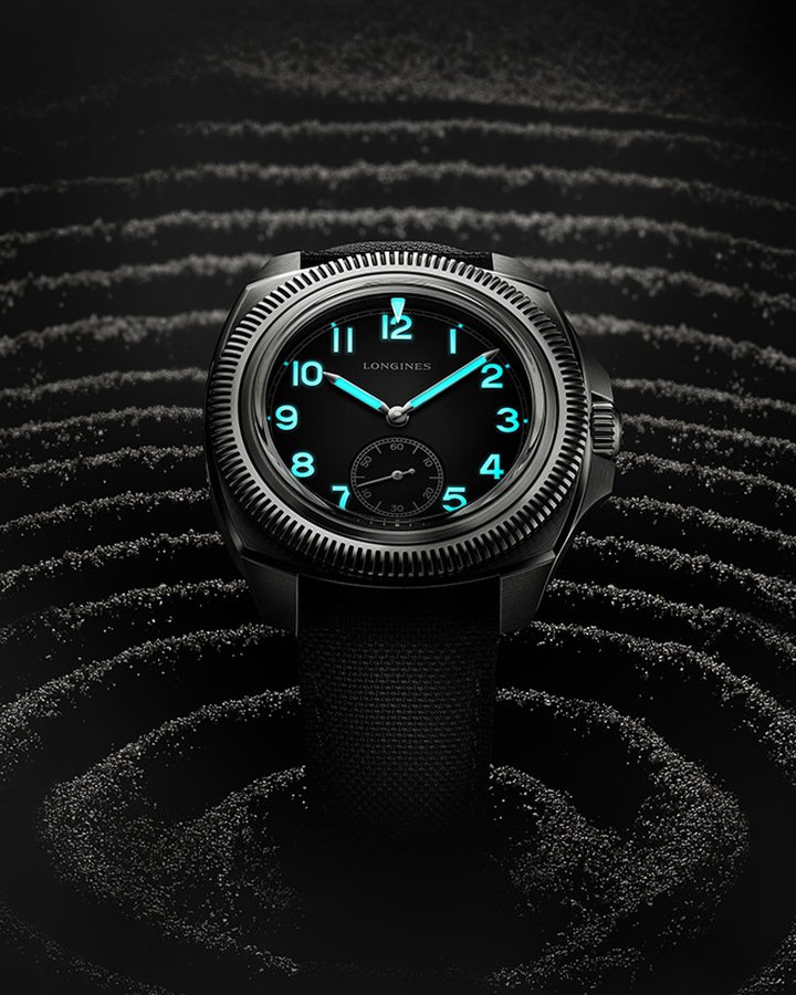 Pilot Majetek钛金属腕表具备哑光黑色粒纹面盘，镀有灰色Super-LumiNova®夜光涂料、散发蓝光的凸起阿拉伯数字标示小时，并搭配铁轨式分钟刻度环的衬托。