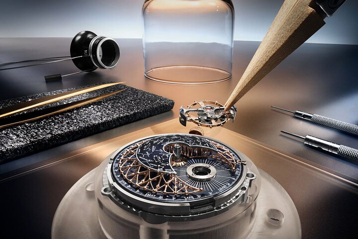 腕表的三层式穹顶形表盘，由珍稀工艺工作坊 (Métiers Rares™ Atelier) 的能工巧匠手工装饰，尽显天文主题之美，尤其是 Cosmotourbillon 天文飞行陀飞轮的设计，新增金银丝 “Atomium” 原子球结构，犹如星空图上连接不同星座的线条。