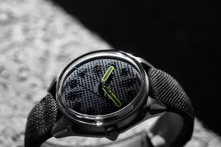 Projekt 01 Variant E腕表采用碳灰色弹性织布一体式表带，并搭配压铸钢制钩扣。