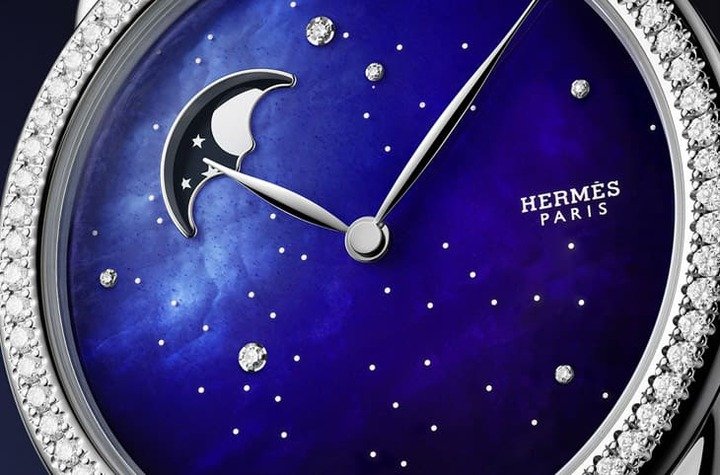Arceau Petite Lune ciel étoilé小月相表的珍珠母贝面盘涂上蓝漆后，搭配钻石装饰更有璀璨夜空的效果，而月相视窗周围的蓝色色调相对浅，看起来犹如月光由近到远的变化。