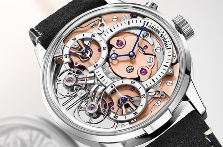 偏心开放式设计展露机芯结构，右侧奶油白漆面时分盘配蓝钢指针，左侧双秒针共振装置形成视觉焦点。