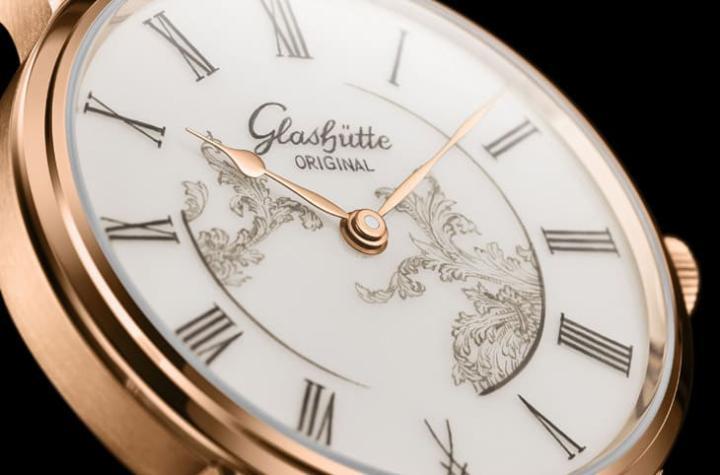 瓷质表盘经 1400°C 高温烧制成形，再以 900°C 反复窑烧上色，确保表面平整与色泽稳定。