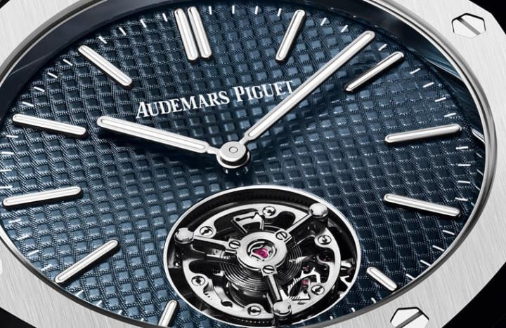 面盘采用皇家橡树经典的“云夜蓝50”色调，同时白色爱彼Logo与刻度乃是皆直接印在格纹面盘上，展现手表的现代革新样貌。