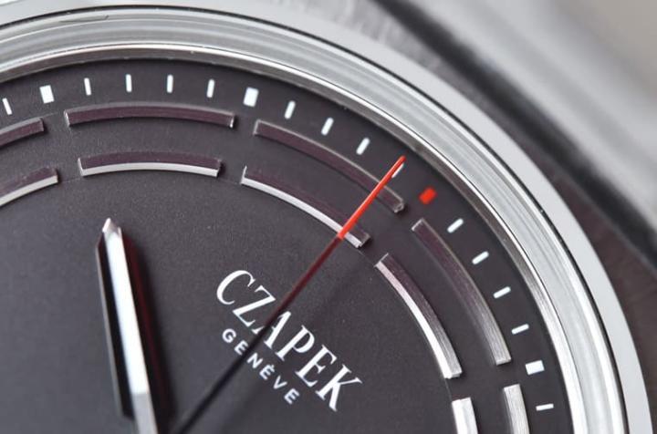 灰色调的面盘仅有12点刻度与秒针针尖为红色，让人据以清楚辨识时间足迹。