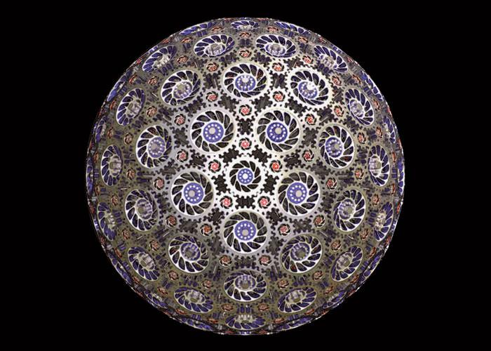 “这里有242枚相互交错的锥齿轮自由旋转组成球体的表面。这个球体由12枚25齿蓝色齿轮、30枚30齿黄色齿轮、60枚14齿橘色齿轮以及140枚12齿的小型红色齿轮构成。”– Paul Nylander，bugman123.com