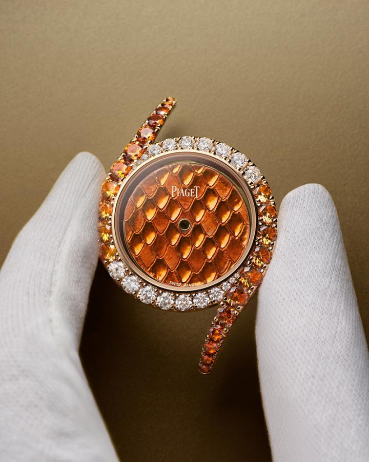 以火焰般的亮橙色为主调，先于表盘上镌刻宫廷式雕刻纹饰，再以经过逾 800 度高温反复烧制的橙色大明火珐琅覆盖于表面。