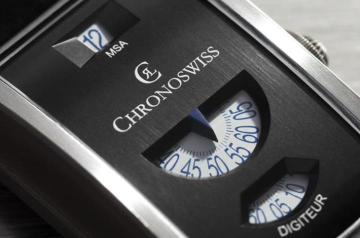 手表采用无指针校时器布局，12 点瞬跳小时、中央数位分钟、6 点流动秒盘，白底蓝字低调又清晰。