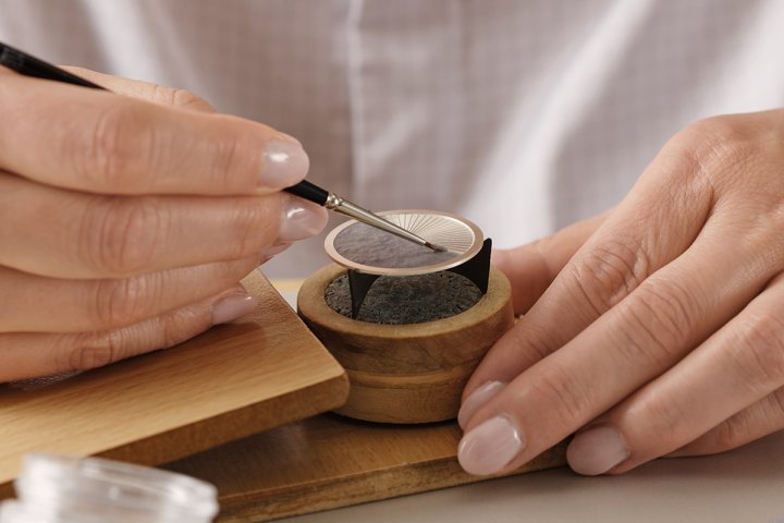 珐琅釉料逐层均匀涂覆于表盘，再经窑炉以约800℃的高温反覆烧制五至十次，最终形成带有自然光泽的无瑕表盘。