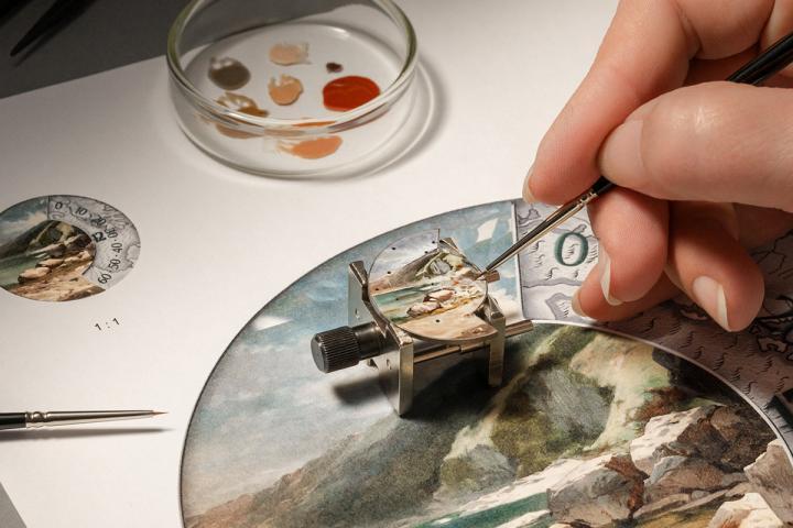 珐琅彩绘背景由工艺大师凭借超凡的耐心与精准技艺，历时 50 小时手工制作而成。首先需在 18K 白金基底上悉心涂覆五层白色和乳白色珐琅釉料，并逐层以高温烧制固色，为天空、河流与大地饰以光泽闪烁的迷人底色。