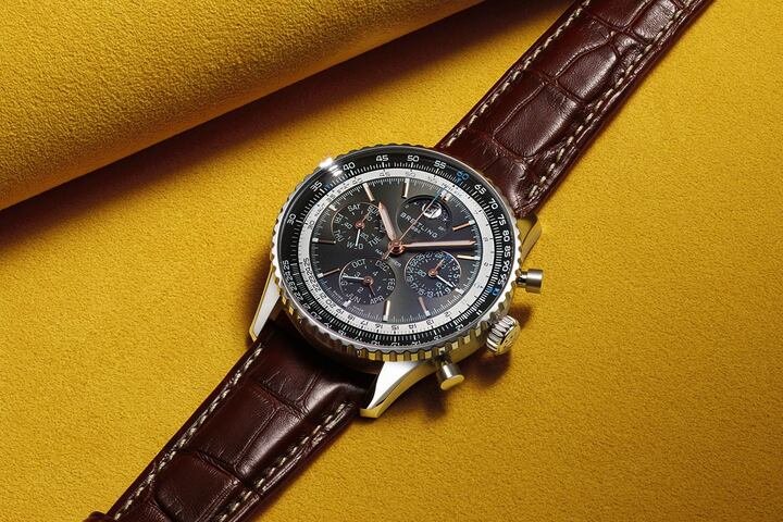 Navitimer B19 43 毫米万年历计时腕表表盘呈现深邃层次与细腻光泽，而小表盘周围的金属凸环则带来全新的立体结构感。12 点方向位置的月相显示以细节吸引目光，每一只表壳皆饰以百年灵经典滚花表圈。