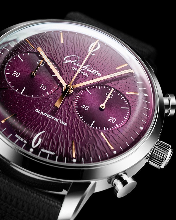 Sixties Chronograph 的紫色表盘以细薄的青铜条为基底。首先透过压印工序形成精致纹理，再裁切成空白表盘并钻出微小孔洞。经过铣削后，表面呈现独特的 “黑胶” 质感：细致的平行刻纹，令人联想起黑胶唱片的沟槽。