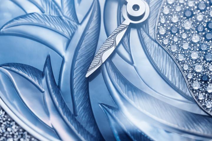 18K白金叶形时针和分针，同样由人手精工雕饰，令腕表的女性柔美感更加浓厚