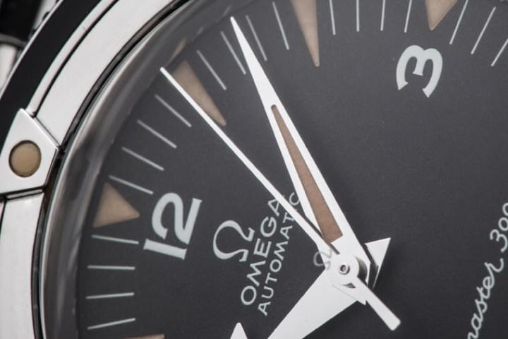 近年OMEGA在海马300 “Spectre”特别版和CK2889复刻版中用过棒棒糖针，相当受到老玩家的喜爱，不过这款却选择了单纯的直式秒针。这版时标数字的笔画末端有稍微突起，这点也跟2014年式不同