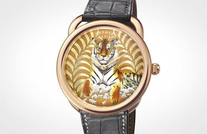 爱马仕以一款丝巾作品（Tigre Royal王者之虎）为蓝本，借由金雕与珐琅工艺，青出于蓝把同样的图案完整移植到Arceau系列腕表上