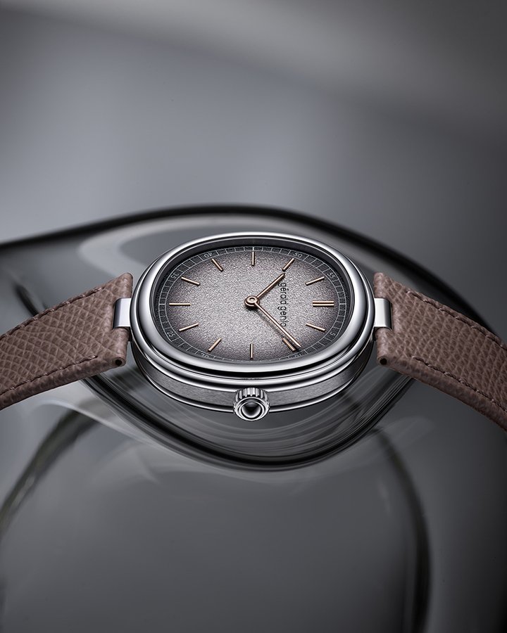 Geneva Time Only Grafite 腕表展现冷冽金属气息，以白 K 金表壳搭配银灰色调的颗粒质感黄铜表盘。圆润的金质指针与时标为画面增添层次与对比，向尊达先生钟爱、富有个性的工艺美学致意。这款腕表搭配灰色小牛皮表带。