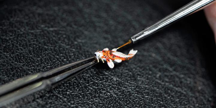 此锦鲤由品牌工艺大师采用金料以手工精雕而成，与漂浮于水面的活动莲花相呼应