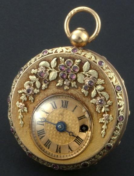 1815年诞生的怀表，黄金制成，雕饰花卉图案镶嵌石榴石。机刻雕花偏心表盘缀有罗马数字。