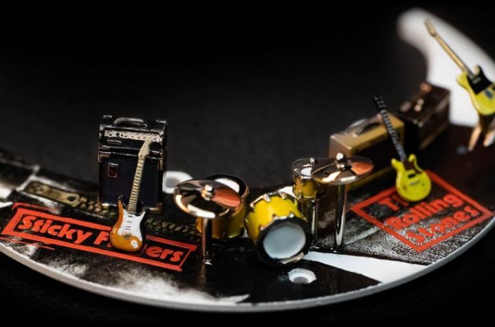 黑玛瑙小表盘下缘的面盘设置了滚石合唱团成员的微型立体乐器装饰，从吉他、鼓组到键盘都有。